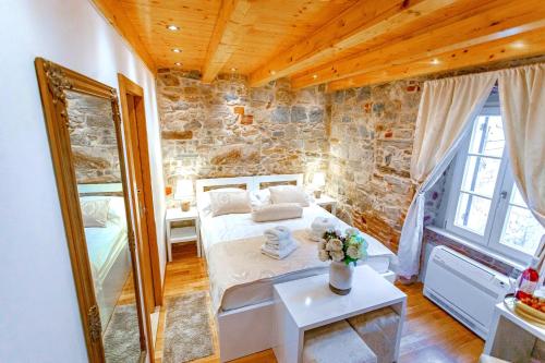 a bedroom with a bed and a stone wall at New Lux Villa Merissima in Split