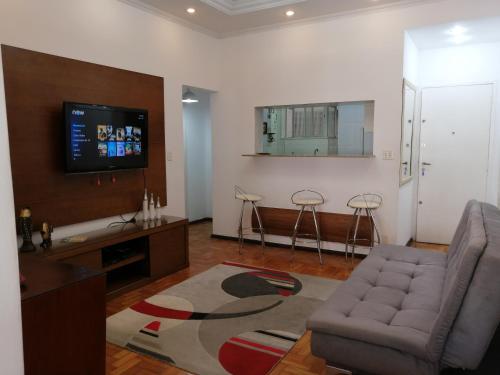sala de estar con sofá y TV de pantalla plana en Sweet Home, en Río de Janeiro