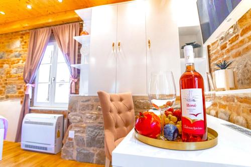 a bottle of wine and a glass on a table at New Lux Villa Merissima in Split