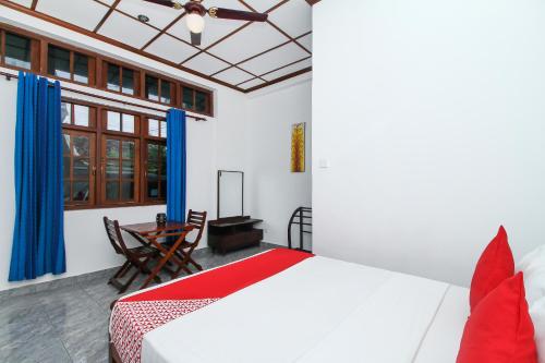 um quarto com uma cama e uma mesa num quarto em Leo's Home Stay em Colombo