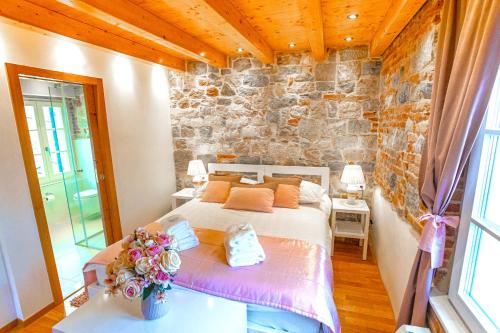 een slaapkamer met een bed en een stenen muur bij New Lux Villa Merissima in Split