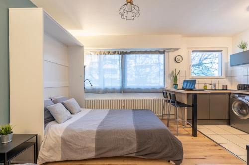 une chambre avec un lit et un bureau et une cuisine dans l'établissement Cosy Studio 110 - Chambéry centre - Stationnement - Gare, à Chambéry