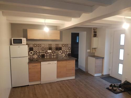 een keuken met een witte koelkast en een magnetron bij maison "Le Goéland" à deux pas des plages in Longeville-sur-Mer