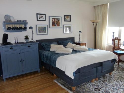een slaapkamer met een blauw bed met kussens erop bij Gastsuite in Valkenburg aan de Geul in Valkenburg