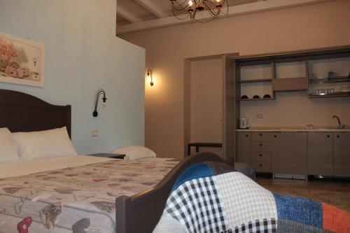 a bedroom with a bed and a kitchen in the background at Case Vacanze Al Duomo in Licata