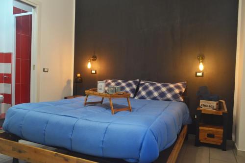 Casa in centro في باليرمو: غرفة نوم بسرير ازرق عليها طاولة