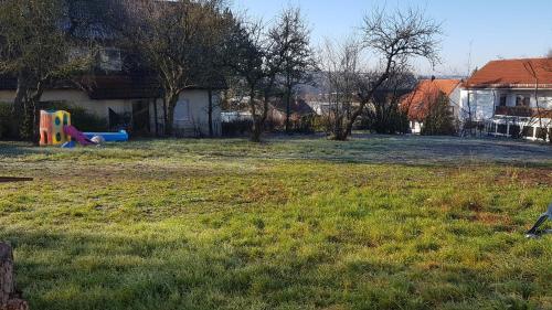 a yard with a playground with a slide in the grass at Ferienwohnung Eyb mit Terrasse und Garten in Ansbach