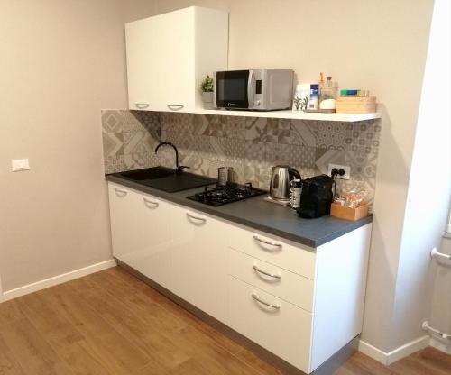 a small kitchen with a stove and a microwave at Bixio Suites in La Spezia