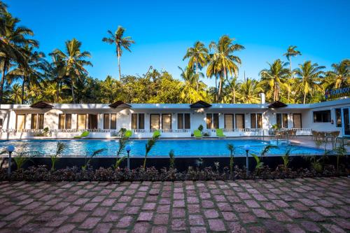 an exterior view of a resort with a swimming pool at Golden Sands Resort, Morjim in Morjim