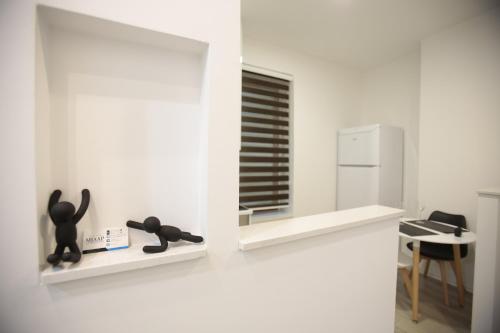 a room with white walls and white shelves and a kitchen at Miaap Apartments in Sarajevo
