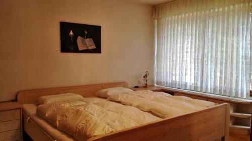 Bett in einem Schlafzimmer mit Fenster in der Unterkunft FeWo Allgäuglück Oberstaufen in Oberstaufen