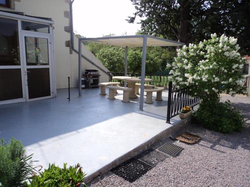 a patio with a table and an umbrella at Gîte La Lieutenance in Saint-Pourçain-sur-Sioule
