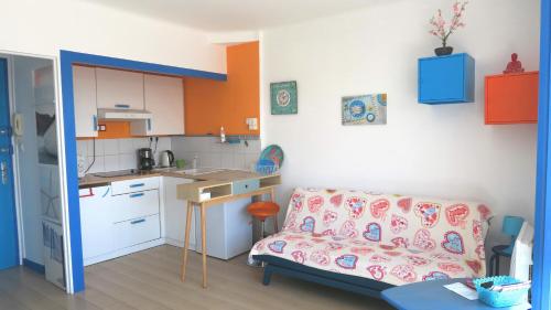 un salon avec un canapé et une cuisine dans l'établissement Studio le long du canal, à Palavas-les-Flots