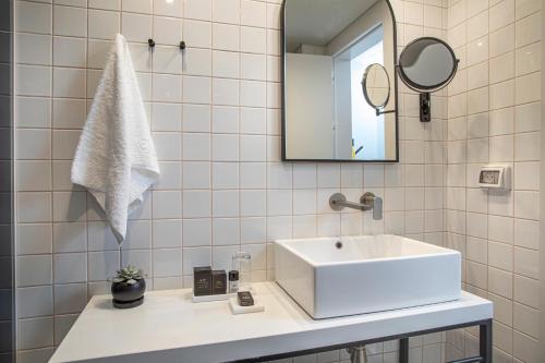 a bathroom with a white sink and a mirror at Artist Hotel - an Atlas Boutique Hotel in Tel Aviv