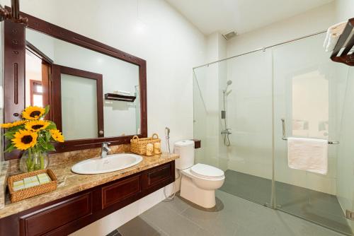 y baño con lavabo, aseo y ducha acristalada. en Green Hill Villa, en Hoi An