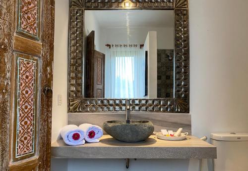 a bathroom with a sink and a mirror at Wide Sands Beach Retreat in Pulukan
