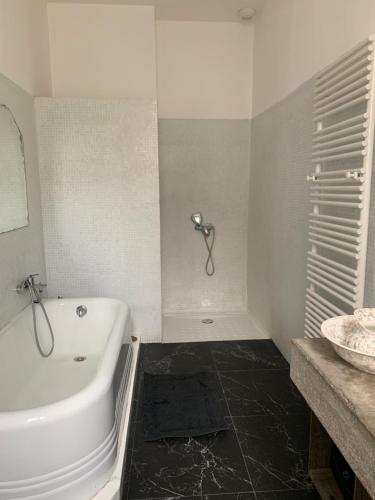 a white bathroom with a tub and a sink at Liberté in Marseille