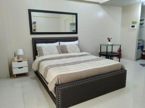 a bedroom with a large bed and a mirror at One Palm Tree Villas close to Manila Airport - Terminal 3 in Manila