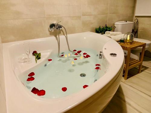 y baño con bañera llena de flores rojas. en Apartamentos CAZORLA-ALCON, en Pozo Alcón
