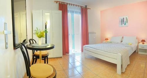 a bedroom with a bed and a table and chairs at Apartments Lori in Poreč