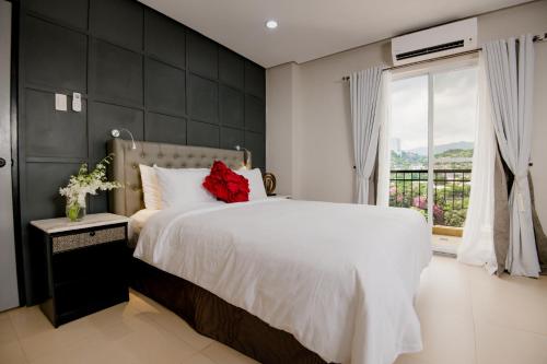 Un dormitorio con una gran cama blanca y una ventana en Sta Barbara Residence Hotel, en Cebú