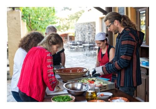 a group of people standing around a table preparing food at Enagron Ecotourism Village in Axós