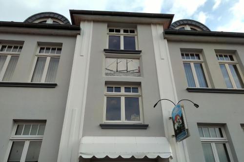 um edifício branco com janelas e um toldo em Hotel Ambiente em Brake