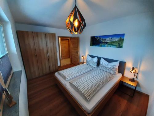 a bedroom with a bed and a chandelier at Apart Alexandra in Strass im Zillertal