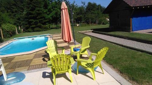 - un groupe de chaises et un parasol à côté de la piscine dans l'établissement Gîte HEINTZ, à Schleithal