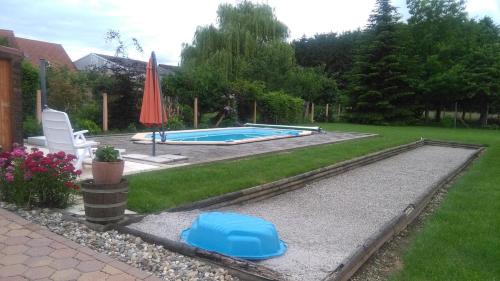 une cour avec une piscine et un parasol dans l'établissement Gîte HEINTZ, à Schleithal
