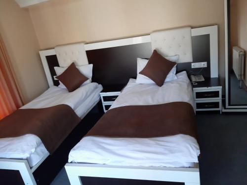two beds sitting next to each other in a room at Meka Hotel in Dragash