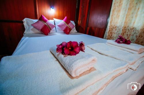 a hotel room with towels and flowers on a bed at Venus Resort in Haad Rin
