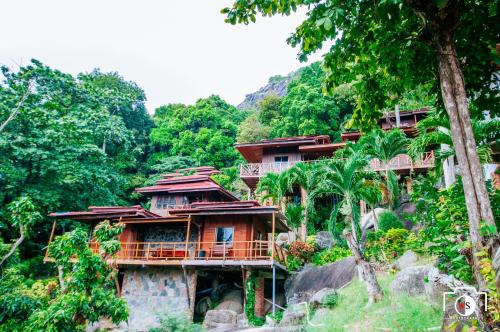 a group of houses on the side of a mountain at Venus Resort in Haad Rin
