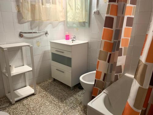 La salle de bains est pourvue de toilettes, d'un lavabo et d'une baignoire. dans l'établissement Apartamentos Domínguez, à Calera