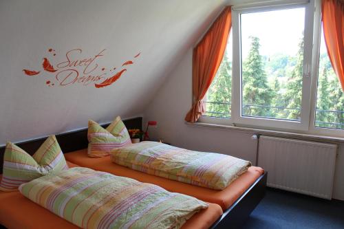 a bedroom with two beds with pillows and a window at Haus Hanseatic Ferienwohnungen in Bad Harzburg