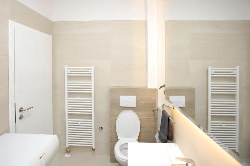 a bathroom with a white toilet and two sinks at Miaap Apartments in Sarajevo