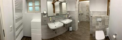 a bathroom with two sinks and two mirrors at Ferienhof Altes Land in Jork