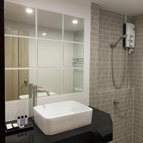 a bathroom with a white sink and a shower at Toptel Thaphra - ท็อปเทล ท่าพระ in Bangkok