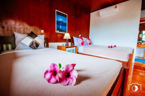 a room with two beds with a flower on the bed at Venus Resort in Haad Rin