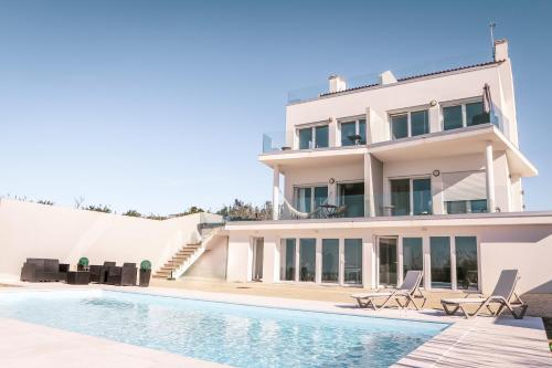 uma villa com uma piscina e uma casa em Marlin House III em Peniche