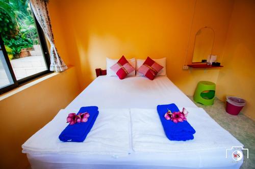 a bedroom with a white bed with two blue slippers at Venus Resort in Haad Rin