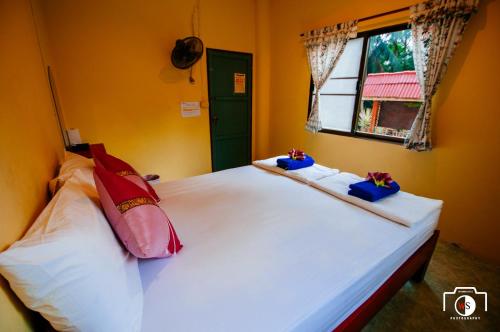 a bedroom with a white bed with chopsticks on it at Venus Resort in Haad Rin