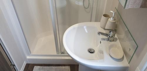 a white sink in a bathroom with a shower at Bonnie Gorm in Boat of Garten