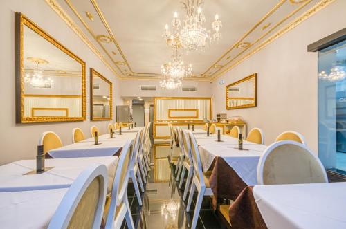 a row of tables in a room with a chandelier at Hotel LX Rossio in Lisbon