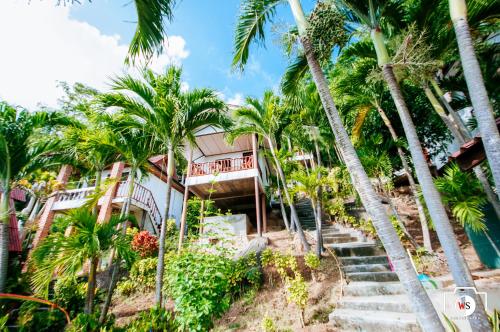a house on the beach with palm trees at Venus Resort in Haad Rin