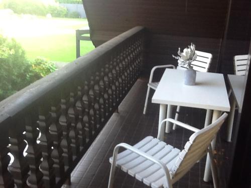 a white table and chairs on a balcony with a table and chairs at Appartement in der Waldsiedlung in Leverkusen
