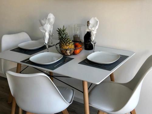 a table with two white plates and a bowl of pineapple at Deluxe Apartments Messe Flughafen in Leinfelden-Echterdingen