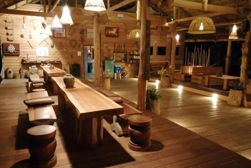 a room with tables and stools in a wooden building at Tad Lo - FANDEE ISLAND - Bolaven Loop Pakse in Ban Kiangtat