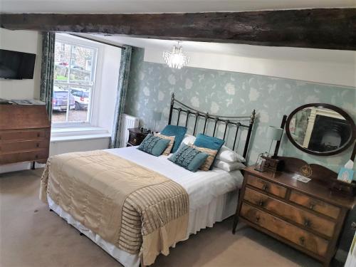 a bedroom with a bed with a mirror and a dresser at Sykes House in Askrigg