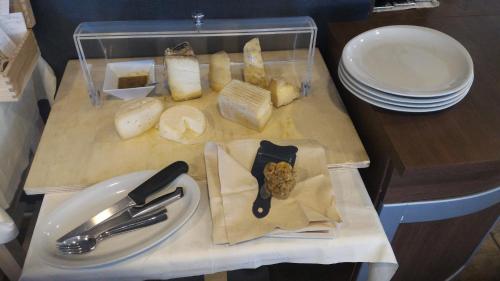 a cutting board with cheese and other foods on a table at Draconerium Hotel in Dronero